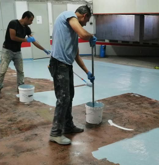 Crew rolling a blue metallic epoxy coating